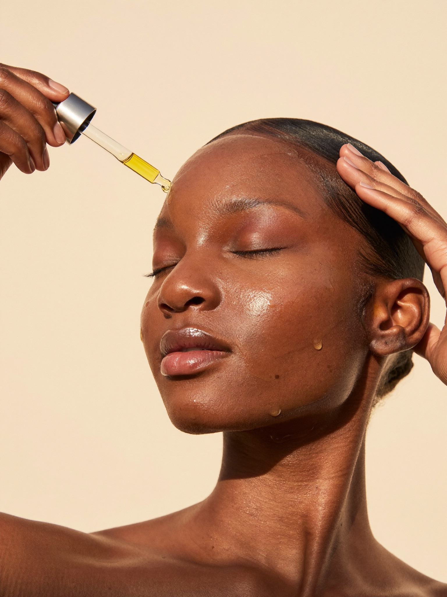 Woman applying glowing facial oil