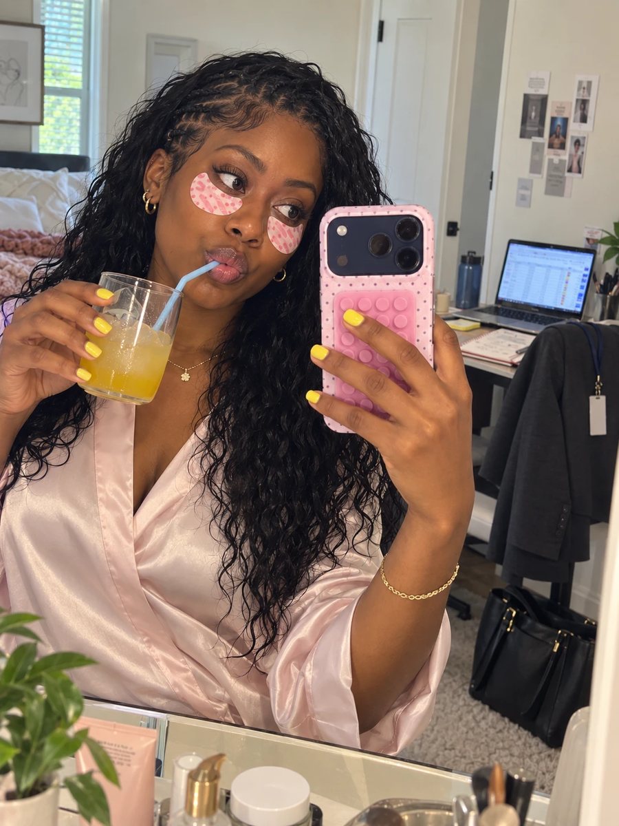 Woman in eye patches taking a mirror selfie before work